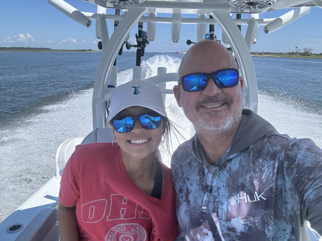 two people smile on a boat