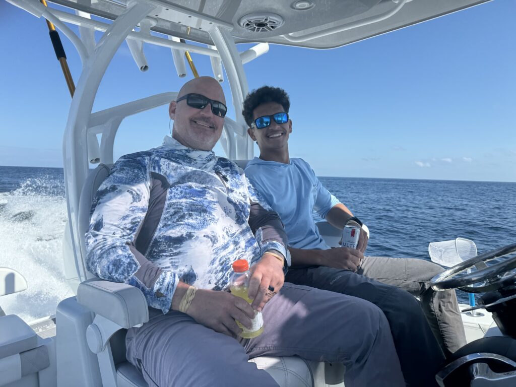 two people smile while sitting on a boat