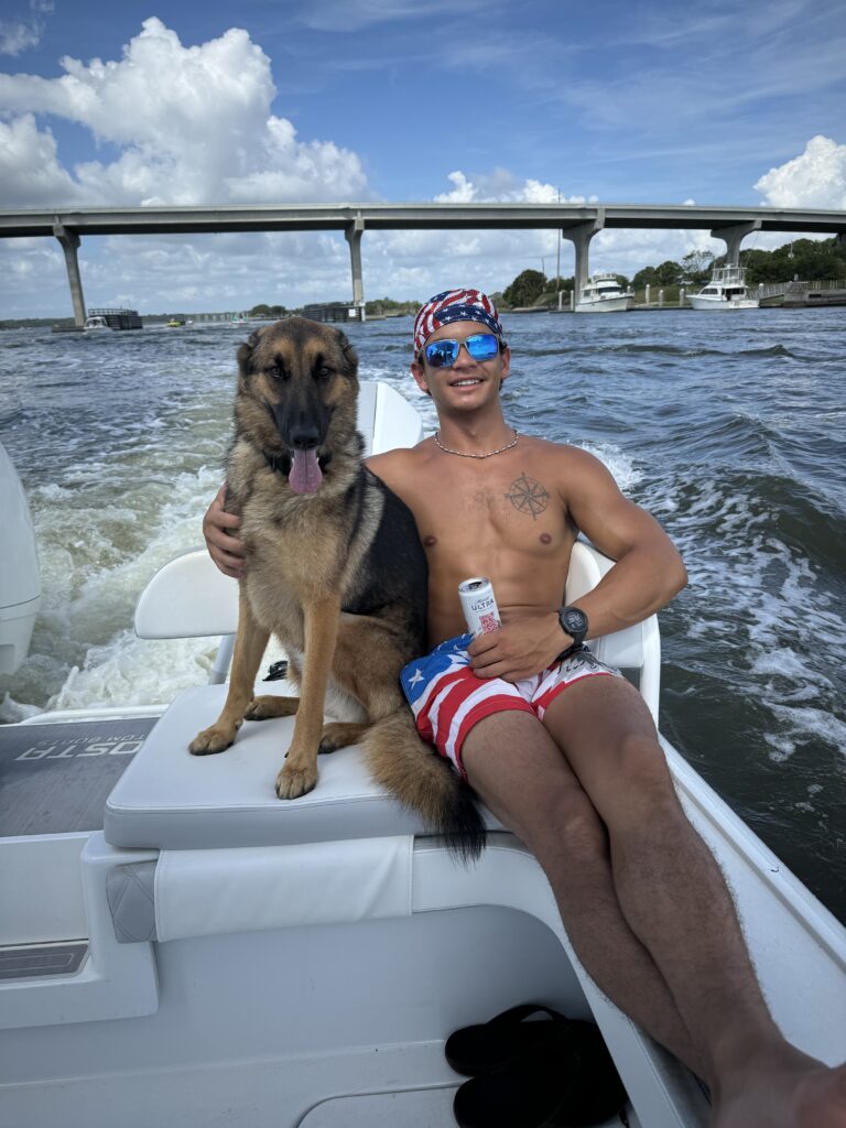 a boy and a dog relax on a boat